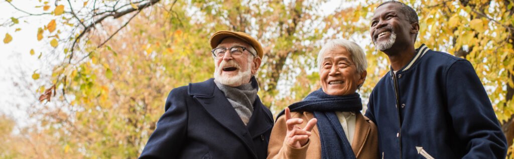 Three smiling older gentlemen in nature