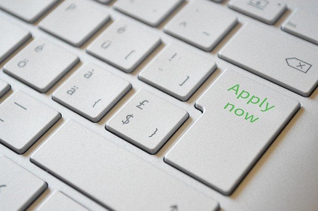 Computer keyboard with the enter key showing "apply now" in green text